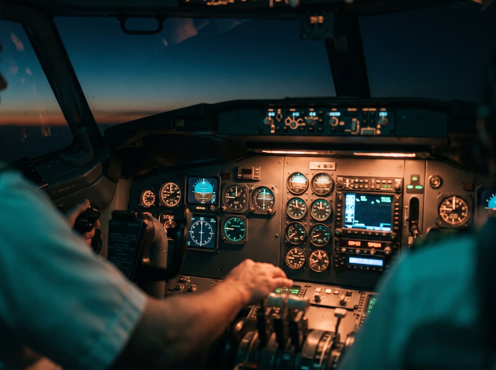 A flight deck at night with the instruments lit
